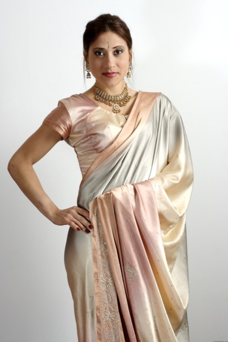 Indian female uncovers her tiny tits as she removes traditional clothing