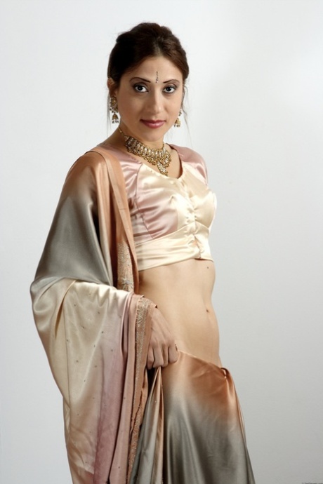 Indian female uncovers her tiny tits as she removes traditional clothing